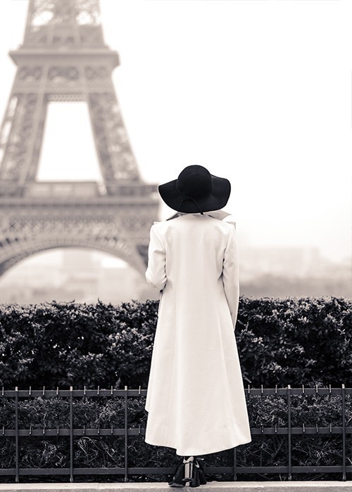 Αφίσα Poster Γυναίκα με άσπρο παλτό που παρατηρεί τον πύργο του Άιφελ 