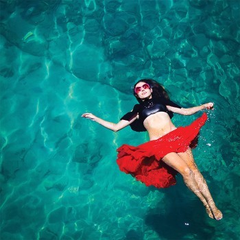 Κοπέλα με κόκκινη φούστα που κολυμπάει